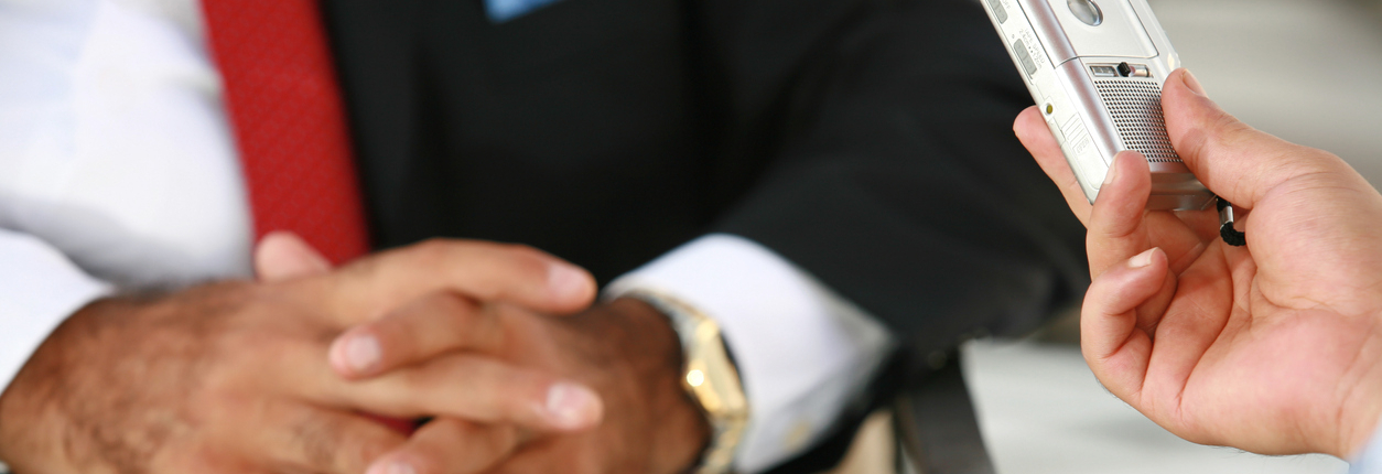 Close-up of reporter's hands, recorder and interview subject